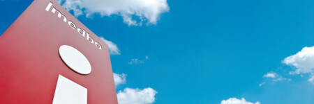 Infopunkt-Säule der medizinischen Einrichtungen des Bezirks Oberpfalz auf dem Klinikgelände mit Blick in den weiß-blauen Himmel 