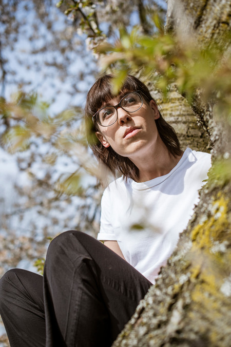 Eine Frau sitzt im Baum.