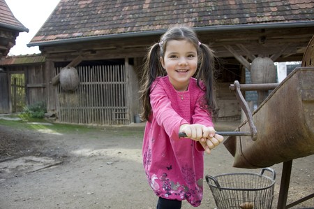 Ein Mädchen dreht an einem Gerät die Kurbel