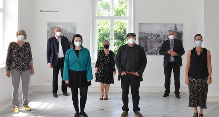 Sieben Menschen vor zwei Kunstwerken.