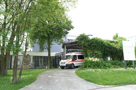 Ein Krankenwagen steht vor der Einfahrt der Klinik