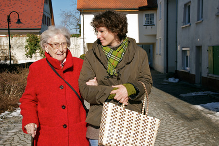 Eine Betreuerin hilft einer älteren Dame einkaufen