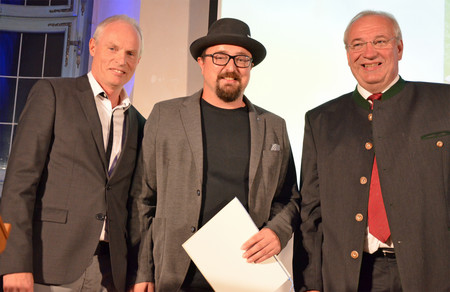 Der Kulturpreisträger 2018 Martin Schönberger freut sich über den Preis. Mit dabei Bezirkstagspräsident Franz Löffler ( rechts) und Kabarettist Norbert Neugirg (links)